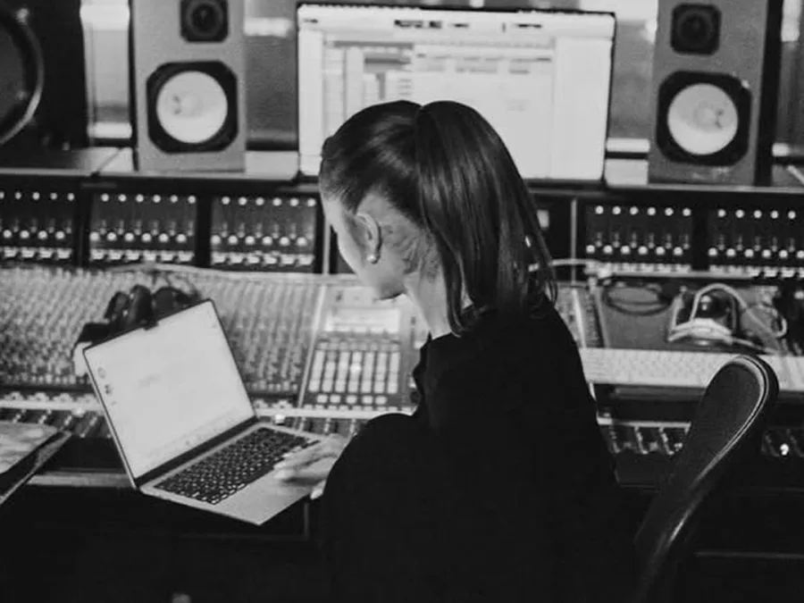 Η Ariana Grande εργάζεται στο studio για το νέο της album, με laptop και κονσόλα ήχου μπροστά της.