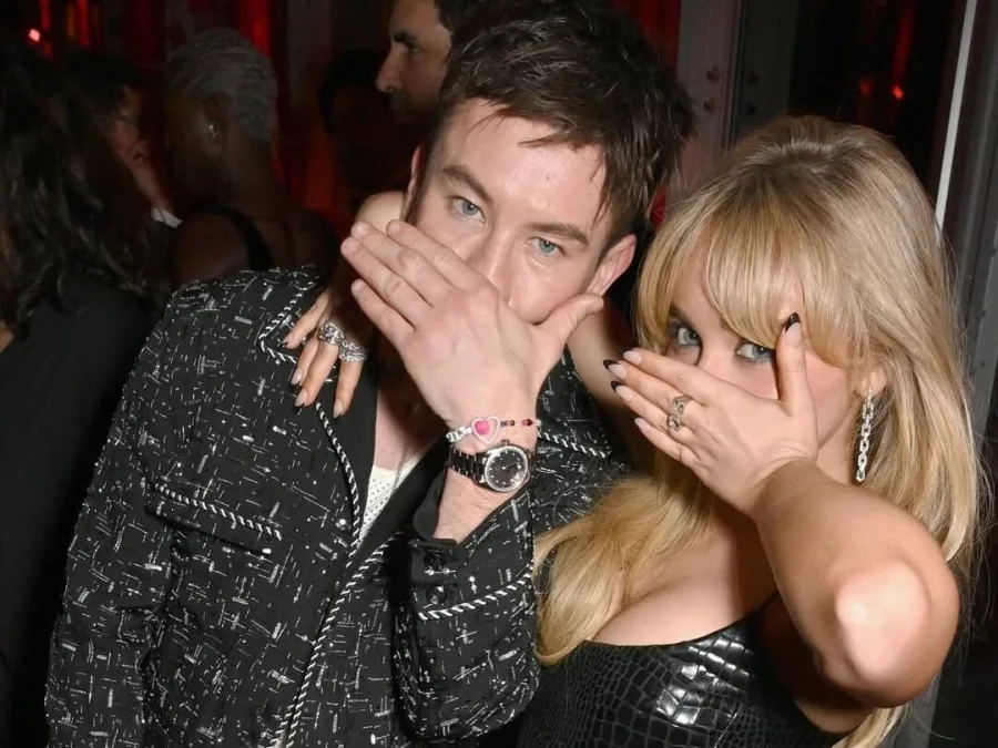 Ο Barry Keoghan και η Sabrina Carpenter καλύπτουν τα πρόσωπά τους με τα χέρια τους.