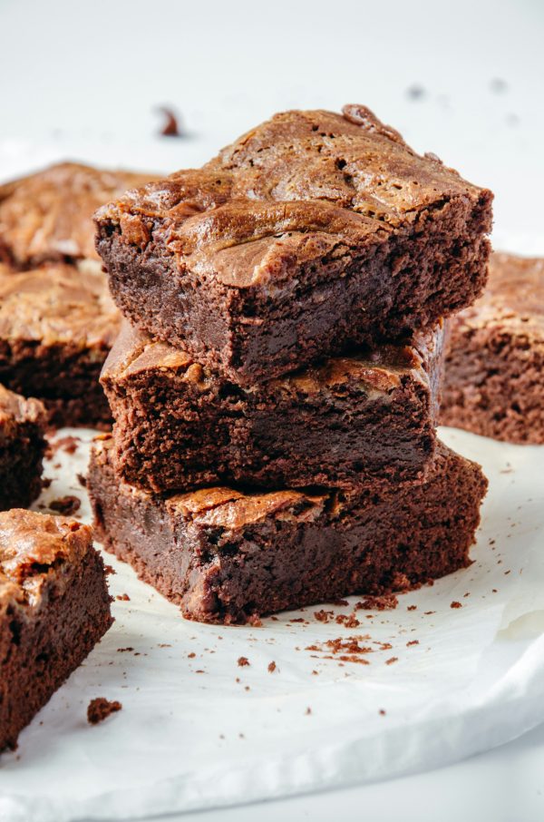 Στοίβα από σοκολατένια brownies, ιδανικά σνακ για άνετο βράδυ σινεμά στο σπίτι, προσφέρουν γεύση.