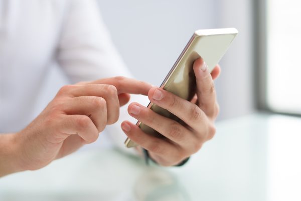 Χέρια που κρατούν και πληκτρολογούν σε smartphone, στέλνοντας μηνύματα, όπως αναφέρεται στα ζώδια.