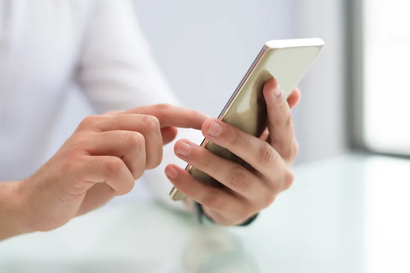 Χέρια που κρατούν και πληκτρολογούν σε smartphone, στέλνοντας μηνύματα, όπως αναφέρεται στα ζώδια.