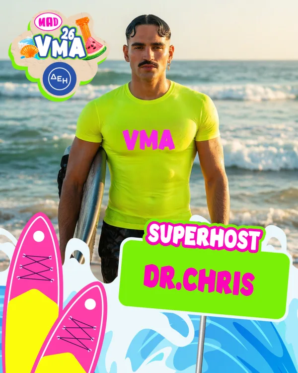 Ο Dr. Chris, Superhost των Mad VMA 2026, με φόντο τη θάλασσα, κρατάει μια σανίδα του σερφ.