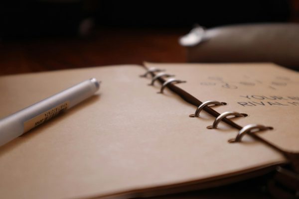 Ανοιχτό bullet journal με ασημί στυλό δίπλα του, ιδανικό για να βάλεις τάξη στη ζωή σου.