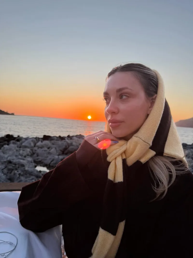 Η Γαρυφαλλιά Καληφώνη απολαμβάνει το ηλιοβασίλεμα κατά τη διάρκεια των πασχαλινών της διακοπών, με φόντο τη θάλασσα.