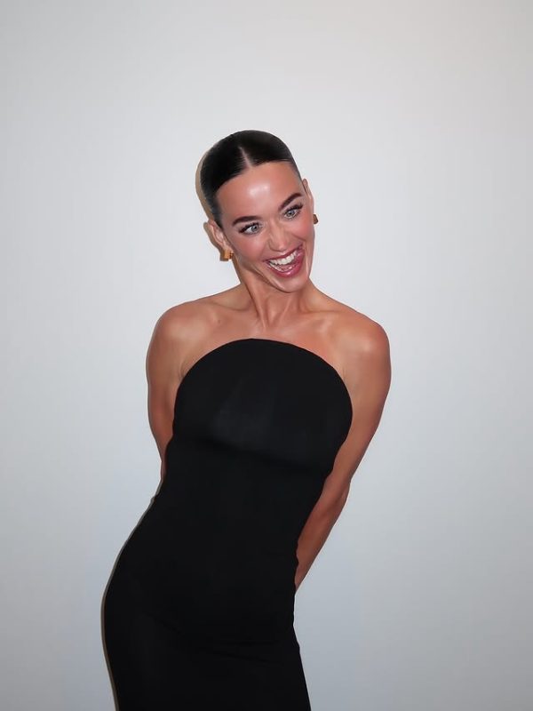 Η Katy Perry χαμογελάει φορώντας ένα μαύρο φόρεμα, ζώντας τον έρωτα στο πλευρό του Justin Trudeau.
