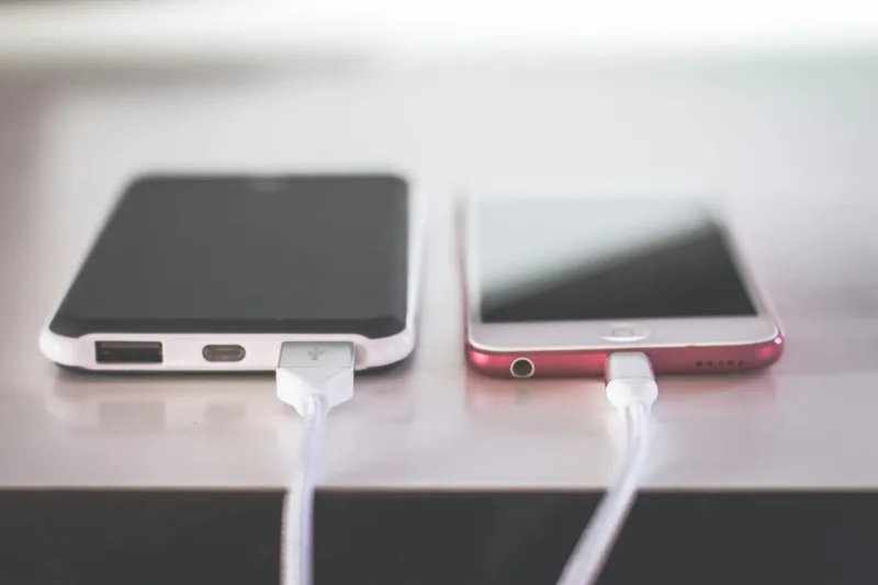 Κοντινό πλάνο ενός smartphone που φορτίζει με καλώδιο για γρήγορη φόρτιση.