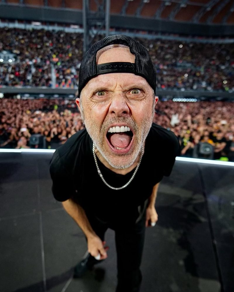 Ο Lars Ulrich των Metallica με καπέλο και ασημένια αλυσίδα, τραγουδάει σε ένα κατάμεστο στάδιο στο ΟΑΚΑ.