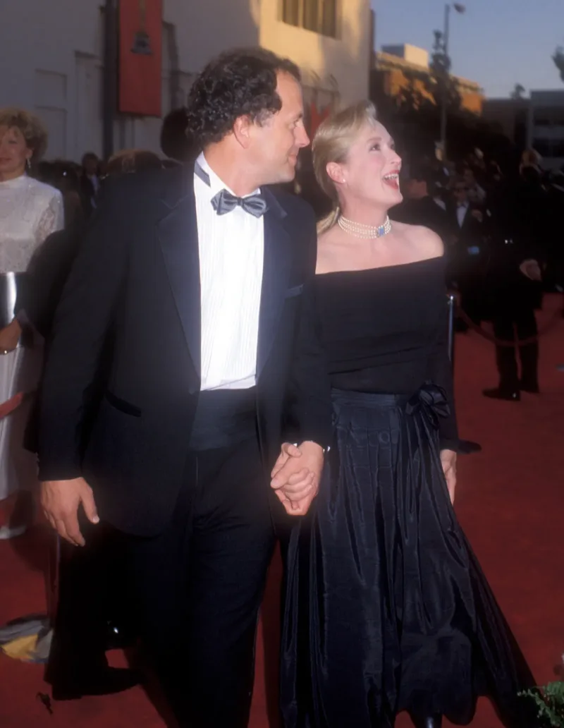 Η Meryl Streep και ο σύντροφός της περπατούν στο κόκκινο χαλί των Όσκαρ του 1989, με το εντυπωσιακό κολιέ της να κλέβει τις εντυπώσεις.