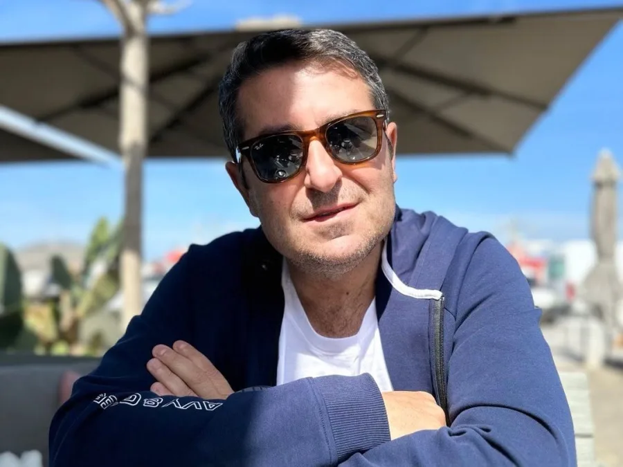 Ο Γιώργος Μυλωνάκης με γυαλιά ηλίου και μπλε ζακέτα, μετά τις εξετάσεις υγείας του.