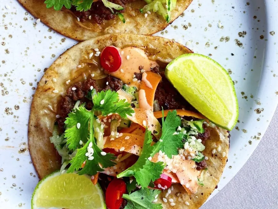 Smashed Tacos με κιμά, λαχανικά και σάλτσα σε πιάτο.