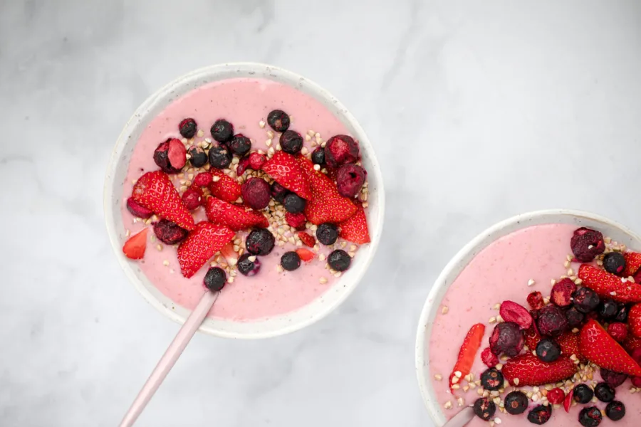 Δύο μπολ με smoothie φρούτων και μούρα, ιδανικά για υγιεινή διατροφή το Πάσχα χωρίς τύψεις.
