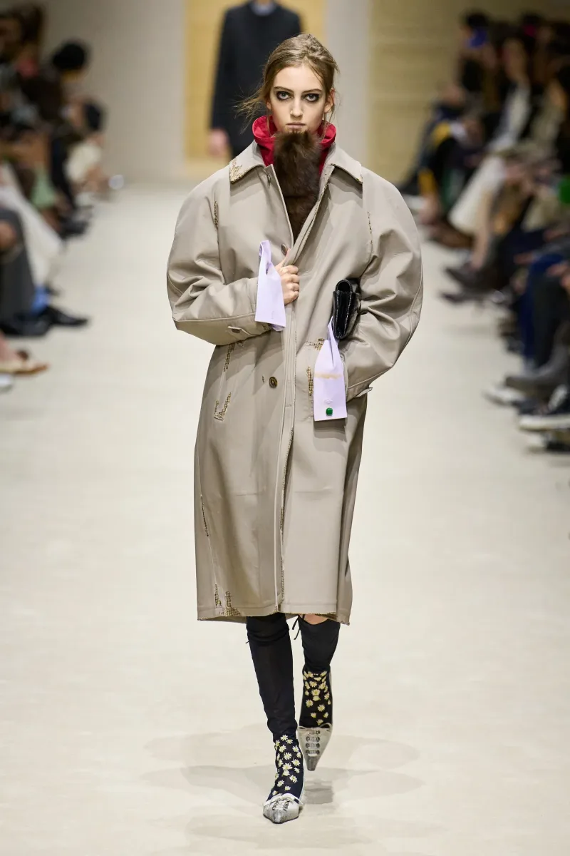 Μοντέλο παρουσιάζει το νέο trench coat trend σε πασαρέλα μόδας, υιοθετώντας το στυλ που προτείνουν οι οίκοι.