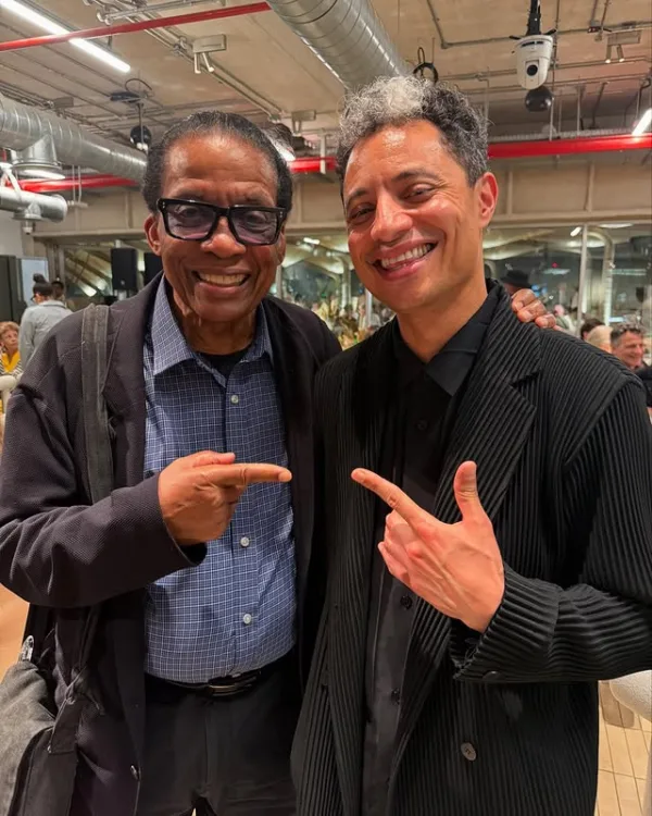 Ο José James και ο Herbie Hancock χαμογελούν και δείχνουν ο ένας τον άλλον σε μια φωτογραφία από την Αθήνα.