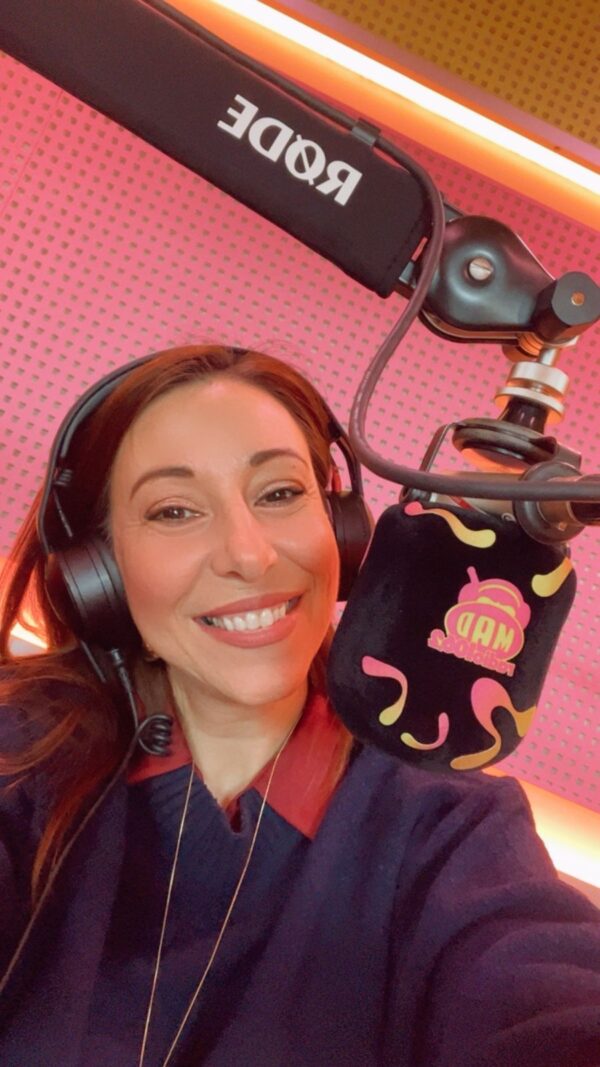 Ραδιοφωνική παραγωγός του Mad Radio 106.2 στο στούντιο με ακουστικά και μικρόφωνο.