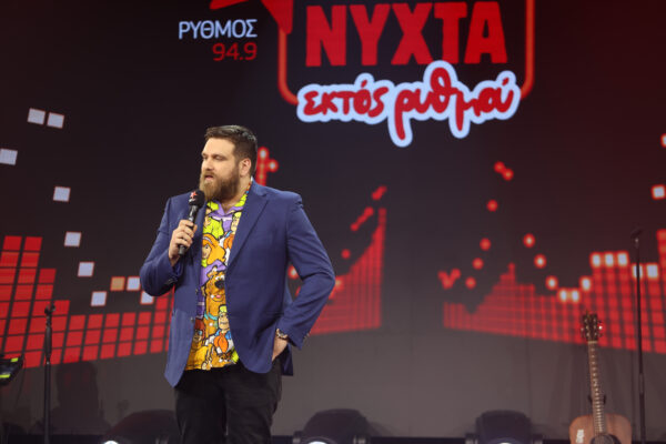 Ο Πάνος Κιάμος με πολύχρωμο πουκάμισο και μπλε σακάκι τραγουδάει στη σκηνή του μουσικού show «Νύχτα εκτός ρυθμού».