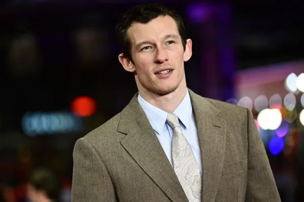 Callum Turner, το νέο πρόσωπο του James Bond, ποζάρει με κοστούμι και γραβάτα σε επίσημη εκδήλωση.