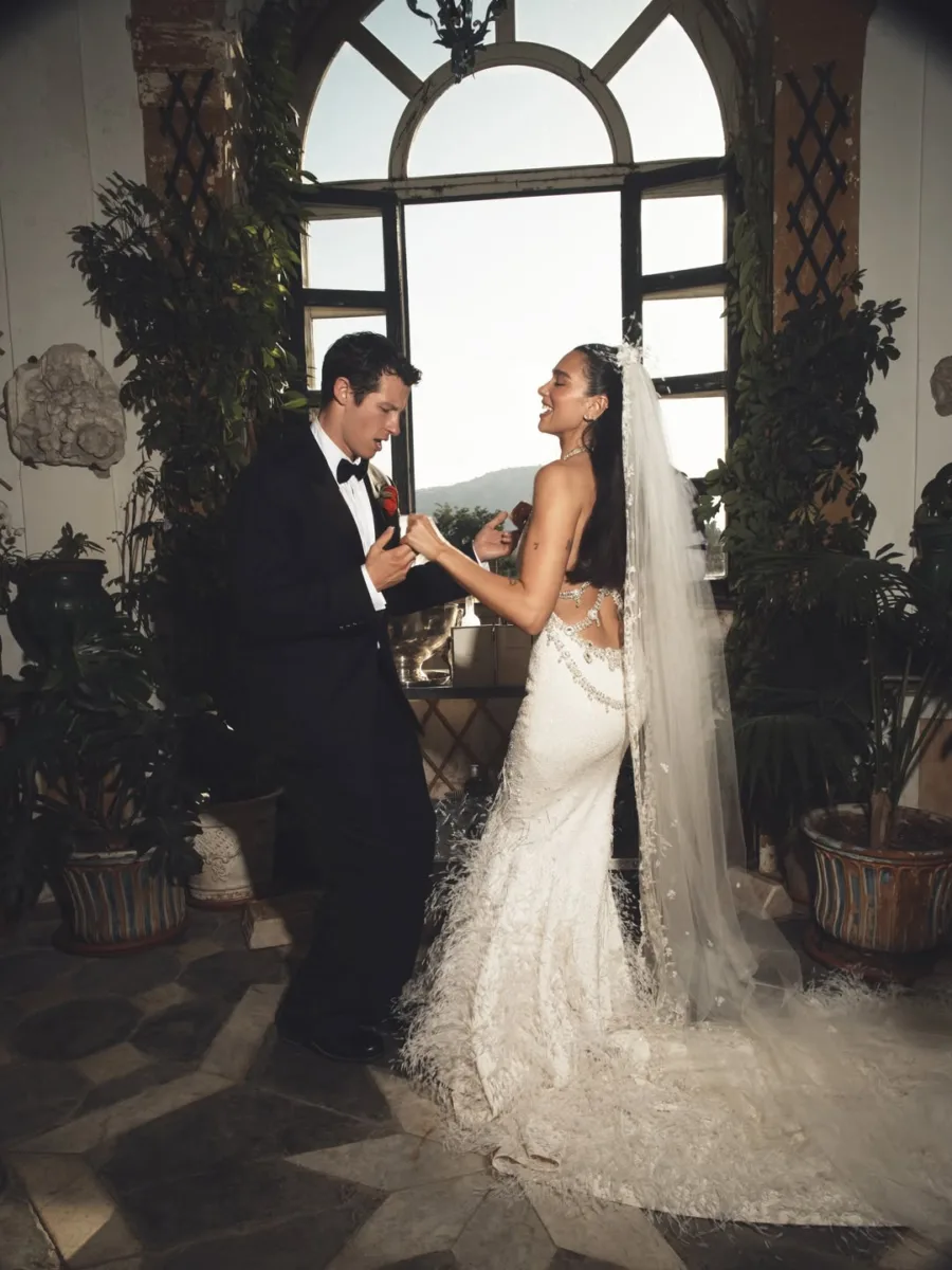 Η Dua Lipa και ο Callum Turner χορεύουν στη Σικελία με νυφικό και κοστούμι, σε σκηνικό που θυμίζει ταινία.