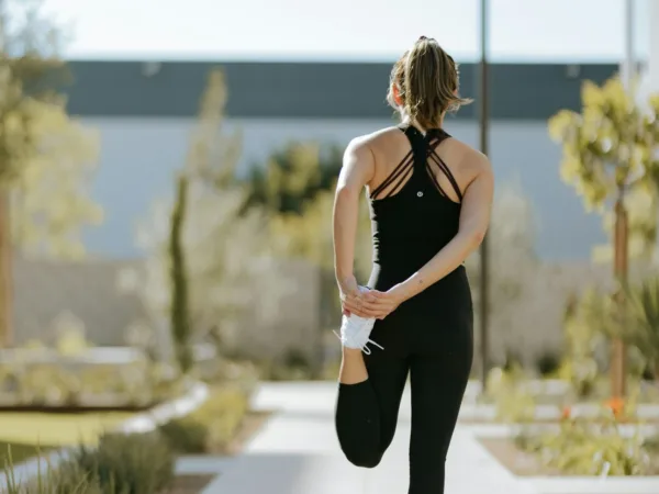 Γυναίκα κάνει διατάσεις για outdoor training, ένα fitness trend που μετατρέπει κάθε χώρο σε γυμναστήριο.