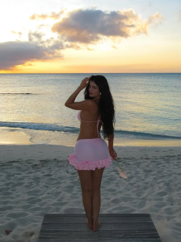 Η Kylie Jenner ποζάρει με ροζ μπικίνι στην παραλία κατά τη διάρκεια ενός εντυπωσιακού ηλιοβασιλέματος.