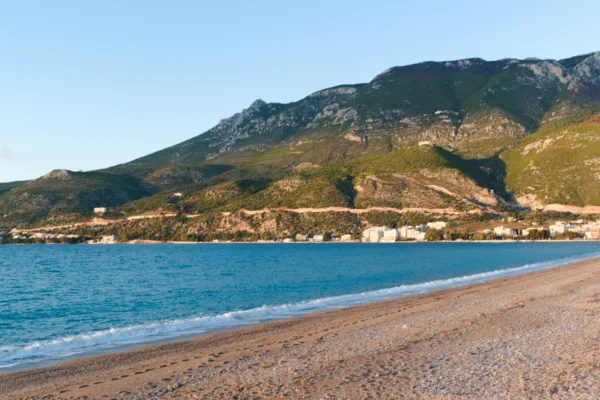 Παραθαλάσσια πόλη με βουνό στο βάθος, ιδανική για μονοήμερη εκδρομή κοντά στην Αθήνα για το καλοκαίρι.