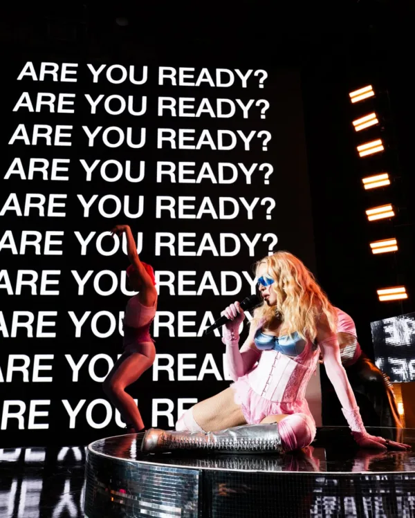Η Madonna σε secret show στην Times Square, με φόντο την ερώτηση "ARE YOU READY;" και χορευτές.