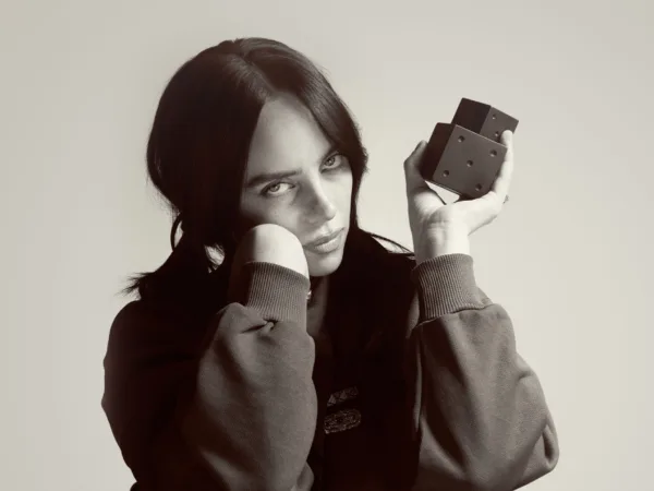 Η Billie Eilish κρατάει ζάρια σε ασπρόμαυρη λήψη, στο πλαίσιο του διαγωνισμού του Mad Radio 106,2.