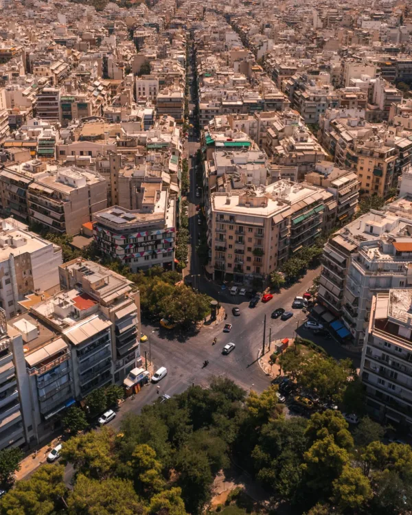 Εναέρια άποψη της Αθήνας με πολυκατοικίες και δρόμους, ιδανική για βόλτες όταν η πόλη αδειάζει.