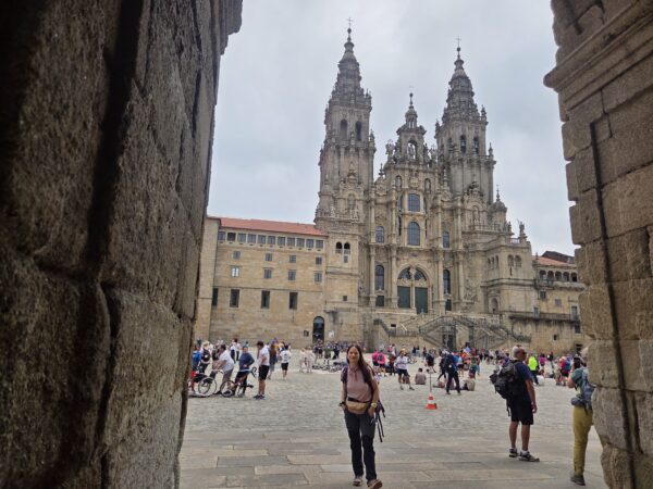 Πεζοπόροι στο Camino de Santiago μπροστά από τον επιβλητικό καθεδρικό ναό, απολαμβάνοντας το ταξίδι που αλλάζει τη ζωή.