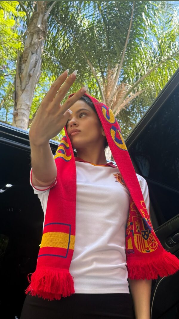 Η Rosalía με κασκόλ και φανέλα της Ισπανίας, δείχνει την υποστήριξή της στο Μουντιάλ 2026.
