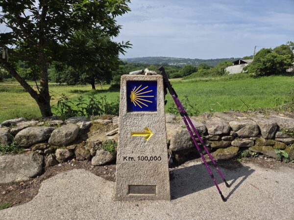 Σημάδι του Camino de Santiago με βελός και μπαστούνια πεζοπορίας, που δείχνει την πορεία προς τον προορισμό.