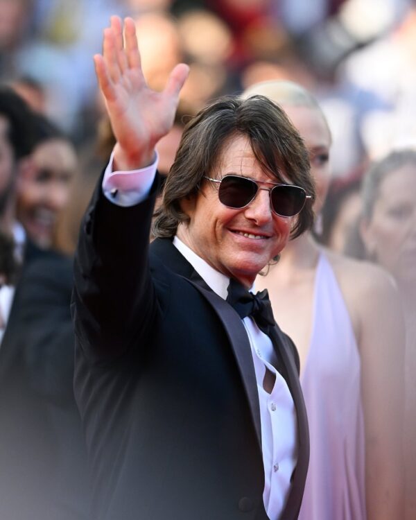 Ο Tom Cruise με μαύρο σμόκιν και γυαλιά ηλίου χαιρετάει σε εκδήλωση