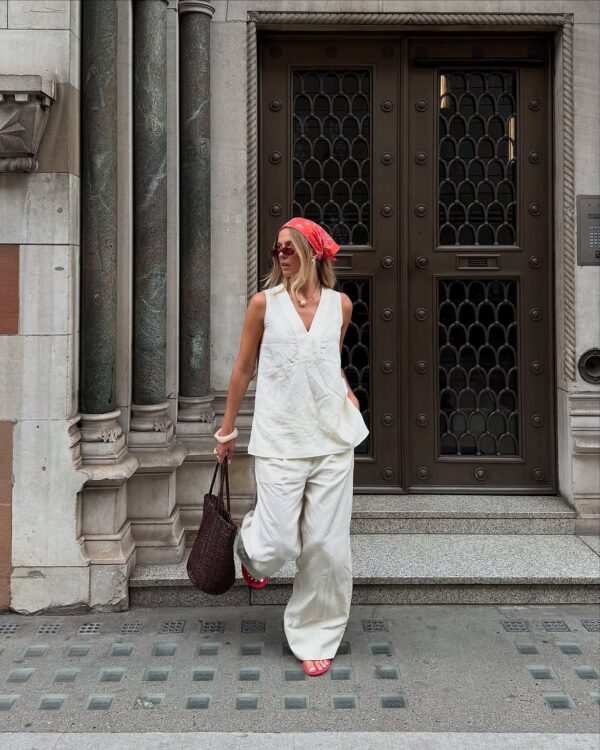 Γυναίκα με λευκό σύνολο και κόκκινο bandana στο κεφάλι, αποδεικνύει την νέα εμμονή με το bandana print.