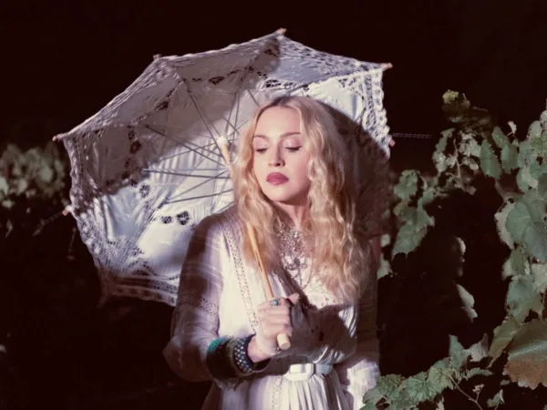 Η Madonna γιορτάζει τα γενέθλιά της με ένα λευκό φόρεμα και ομπρέλα ανάμεσα σε κλήματα.