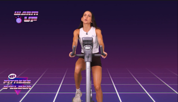 Γυναίκα αθλήτρια κάνει ποδήλατο στο Fitness O’ Clock, ετοιμάζεται για προπόνηση και Ολυμπιακούς Αγώνες.