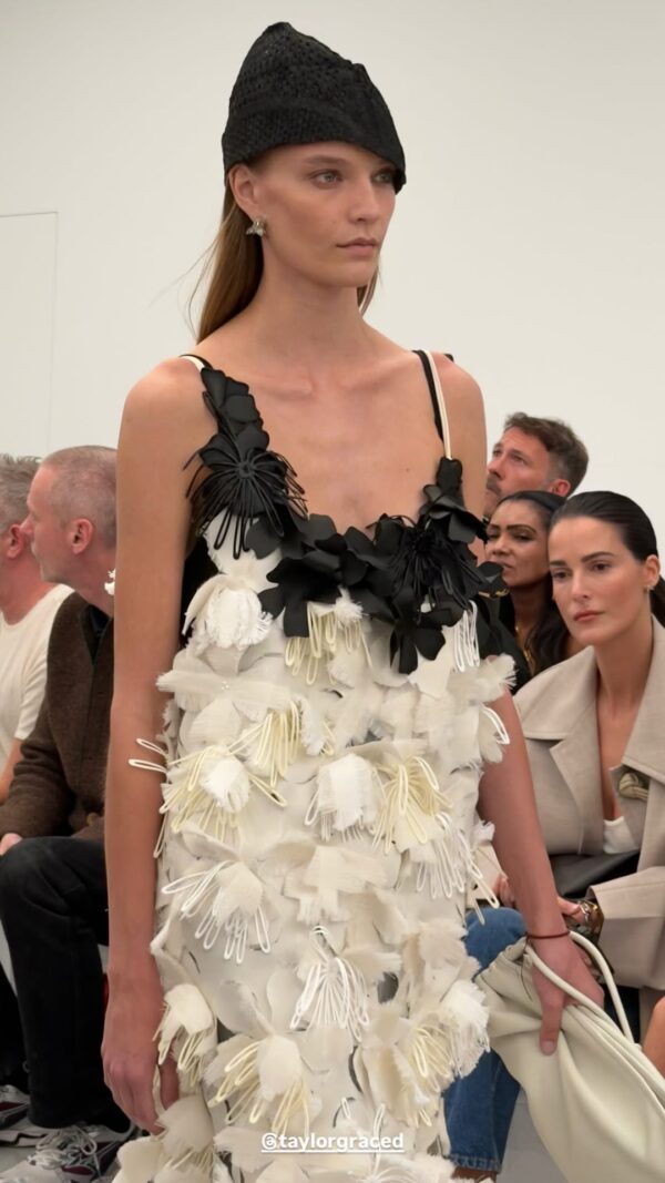 Μοντέλο παρουσιάζει τη νέα συλλογή Bottega Veneta SS27 με ένα εντυπωσιακό φόρεμα και μαύρο καπέλο.