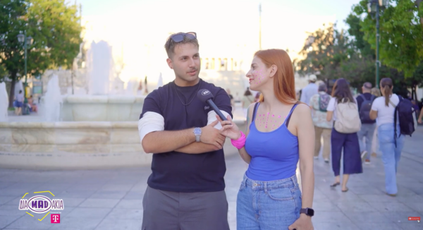 Δύο νέοι συζητούν για τις υποσχέσεις που λέμε κάθε Σεπτέμβρη στον εαυτό μας, με φόντο ένα σιντριβάνι και περαστικούς.