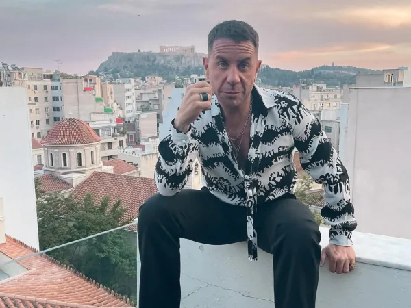 Ο Γιώργος Μαζωνάκης ποζάρει με φόντο την Ακρόπολη, καθώς τα τραγούδια του βρίσκονται στην κορυφή των charts.