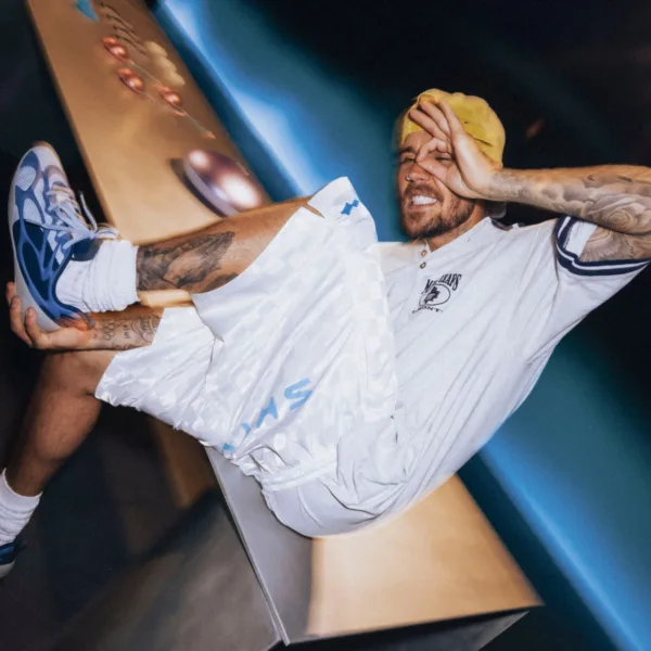 Ο Justin Bieber με κίτρινο σκουφάκι και λευκό σορτς ποζάρει σε ένα quiz για το αγαπημένο του τραγούδι για karaoke.