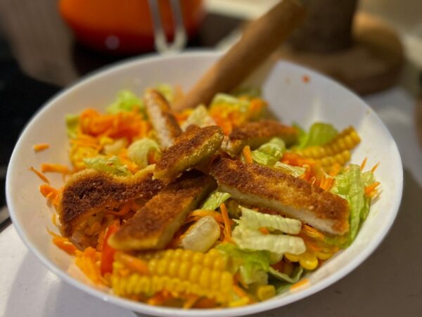 Μακαρονοσαλάτα με κοτόπουλο και λαχανικά σε λευκό μπολ, έτοιμη για ένα χορταστικό γεύμα.
