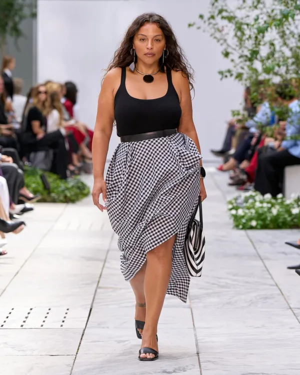 Μοντέλο παρουσιάζει ρούχα Michael Kors στην πασαρέλα, φέρνοντας το πνεύμα της Νέας Υόρκης και της Pop Art για την Άνοιξη 2027.