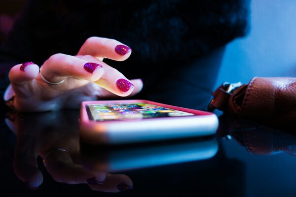 Χέρι με μωβ μανικιούρ χρησιμοποιεί smartphone για να κερδίσει πολύτιμα GB στο κινητό χωρίς να θυσιάσει φωτογραφίες.