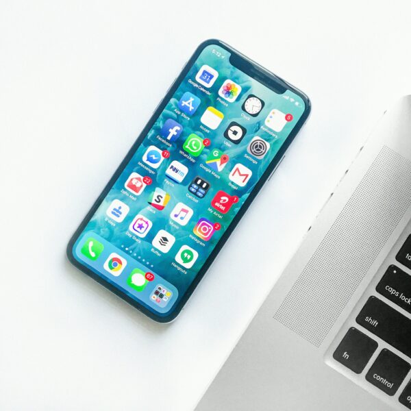 Ένα smartphone με πολλές εφαρμογές δίπλα σε ένα laptop, για να αποκτήσεις πολύτιμα GB στο κινητό σου.