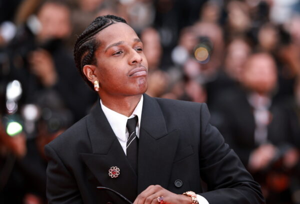 Ο A$AP Rocky με κοστούμι και κοσμήματα, σε μια εκδήλωση με πλήθος κόσμου στο παρασκήνιο.