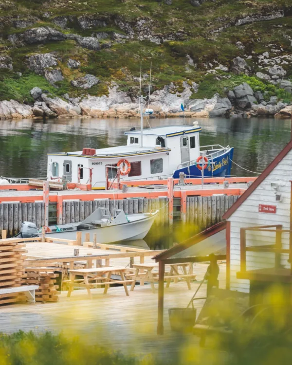 Λιμάνι με βάρκες και ξύλινα τραπέζια στο Battle Harbour, μια πρώην αλιευτική κοινότητα.