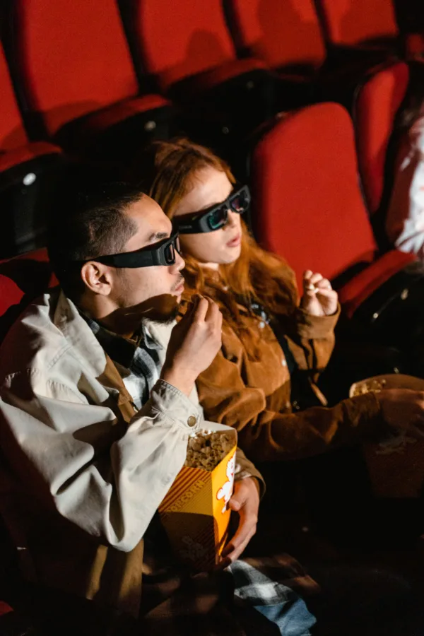 Δύο άτομα με γυαλιά 3D παρακολουθούν ταινία στον κινηματογράφο, τρώγοντας ποπ κορν, ενώ οι σκηνοθέτες χειραγωγούν την ανθρώπινη όραση.