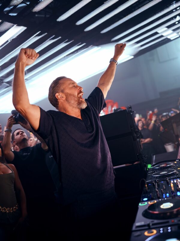 Ο DJ με υψωμένα χέρια σε συναυλία, γιορτάζει την επιτυχία του ως ο Νο1 DJ στον κόσμο.