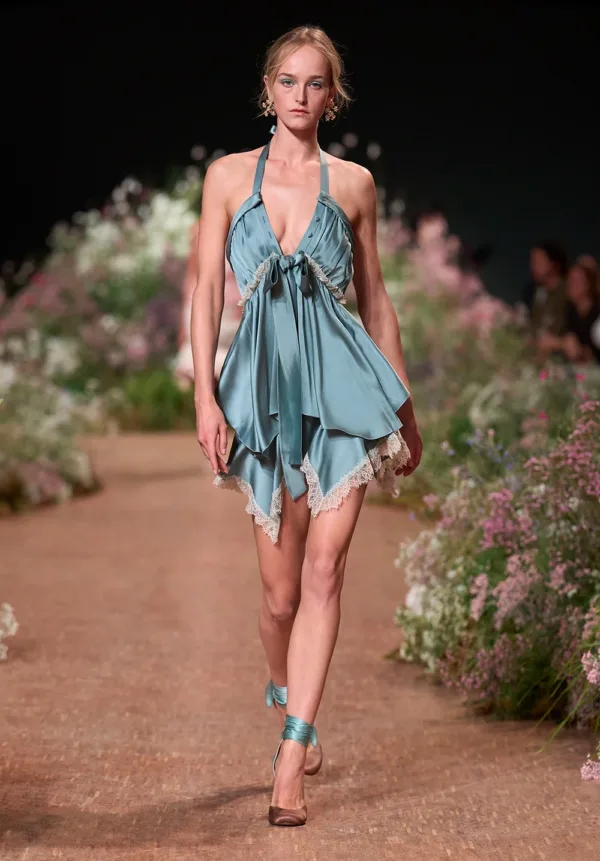 Μοντέλο παρουσιάζει τη συλλογή SS27 του οίκου Elie Saab με ένα κοντό, αέρινο φόρεμα σε παστέλ απόχρωση και δαντελένιες λεπτομέρειες.