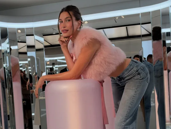 Η Hailey Bieber με ροζ γούνα και τζιν ποζάρει με τον iconic τρόπο της, ακούγοντας το τραγούδι «LUX».