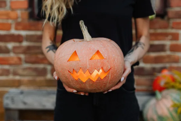 Ένα σκαλισμένο Halloween pumpkin με αναμμένο κερί στο εσωτερικό του, έτοιμο να στολίσει το σπίτι σας.