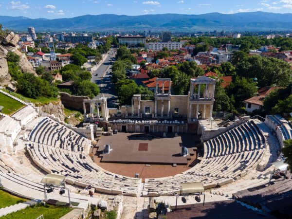 Αρχαίο θέατρο σε έναν από τους ανερχόμενους προορισμούς της Ευρώπης, με την πόλη να απλώνεται στο βάθος.